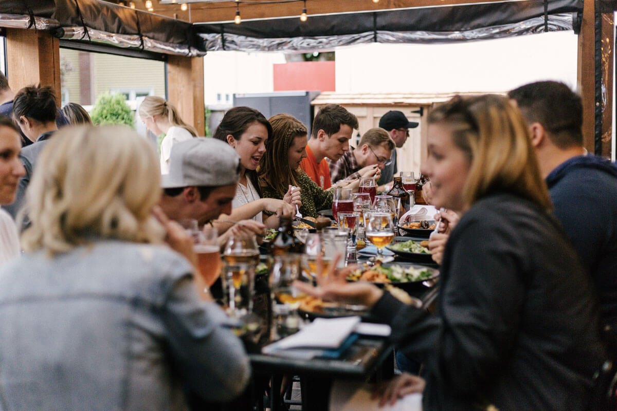 Un gruppo di persone sedeva intorno a un tavolo mangiando e bevendo
