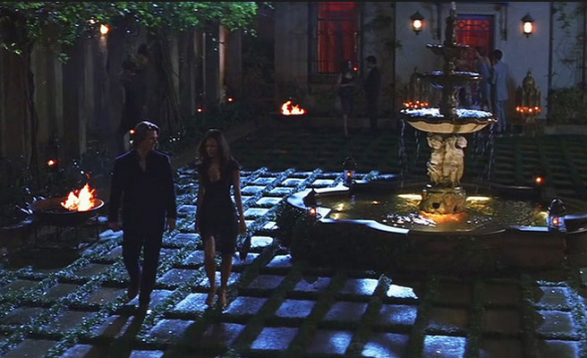 Tom Cruise and Thandie Newton walking besides through a moonlit corner of Seville