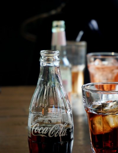 A glass bottle of Coca-Cola and a Calimocho Drink