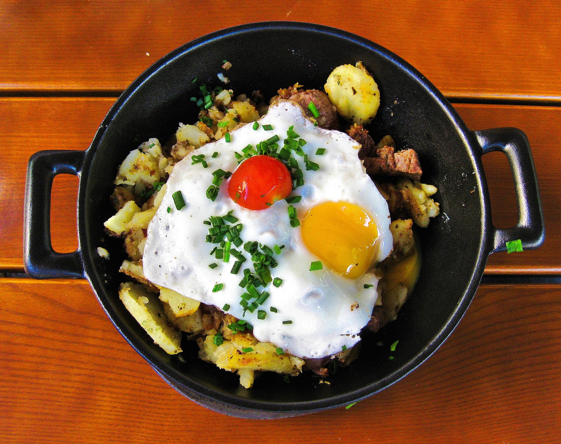 Huevos Rotos cooked in a frying pan on top of a table
