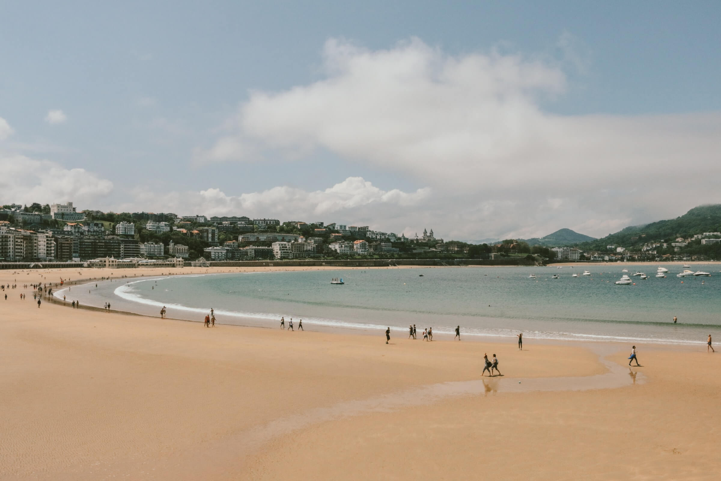 Uma ampla vista de uma praia em Espanha com algumas pessoas na areia